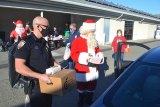 Lemoore Police Chief Michael Kendall and Santa Claus deliver the goods as recipients drive through the department's rear parking lot.